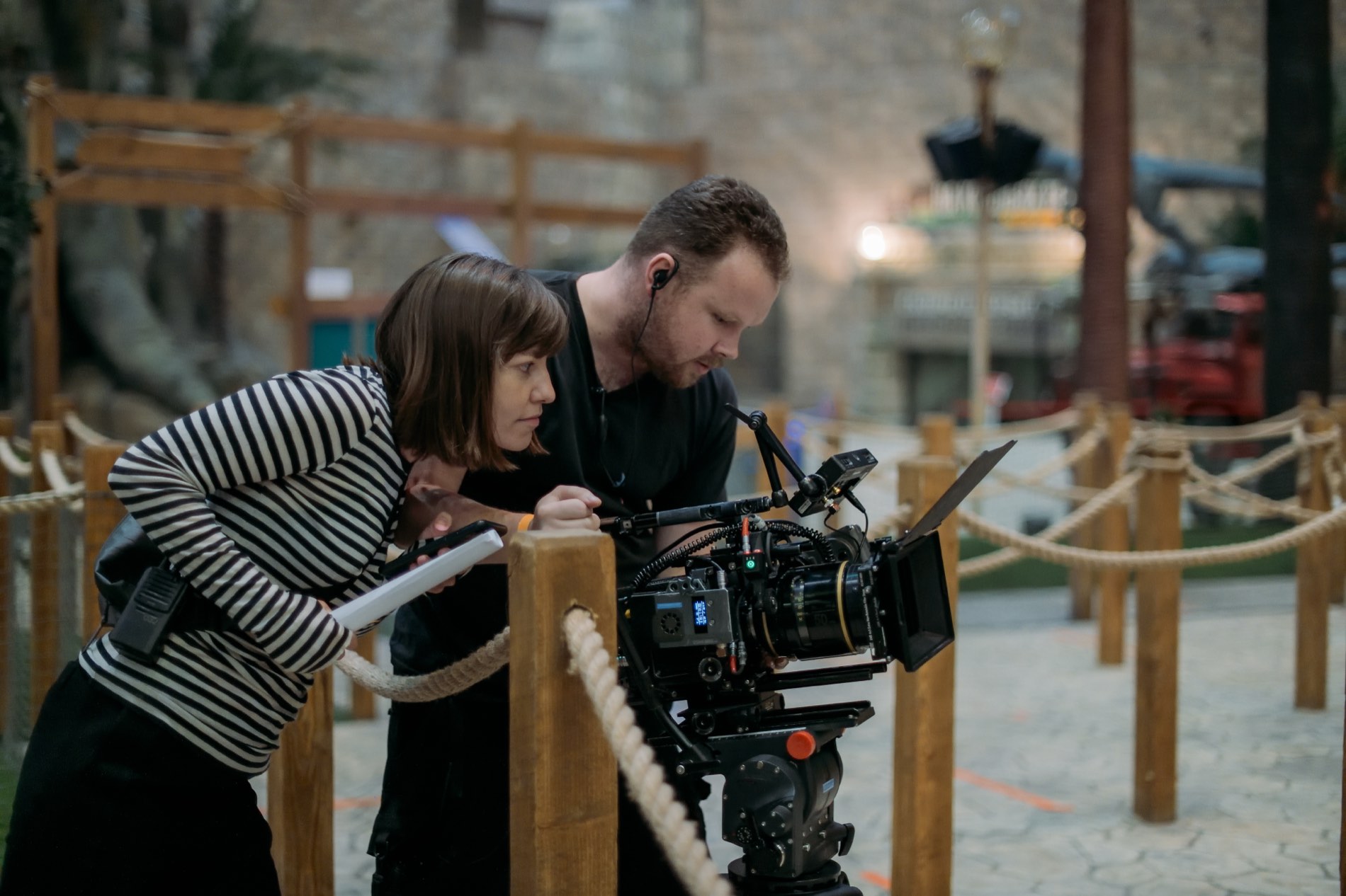 A director and DP review a shot on the camera monitor on set